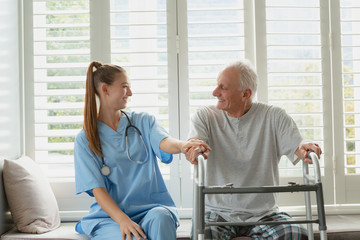 Female doctor consoling active senior man on window seat