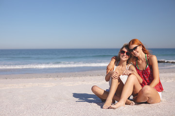 Fototapeta premium Female friends relaxing together on the beach