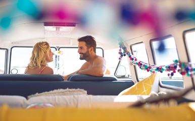 Couple talking with each other in camper van at beach
