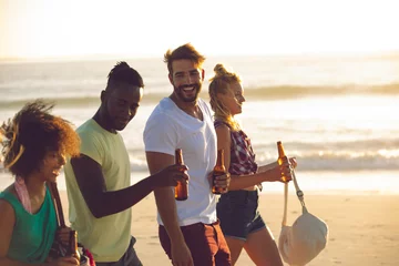 Crédence de cuisine en verre imprimé Bar Group of friends holding beer bottles and walking together on the beach