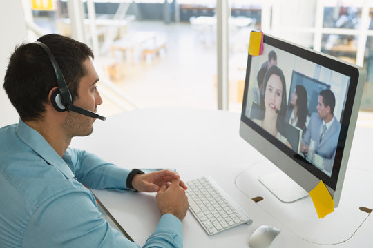Male customer service executive making video call on computer at desk