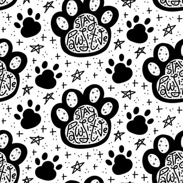 Stay Pawsitive lettering in paw print, black and white seamless pattern