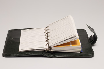 dark green diary with stapler near and pen