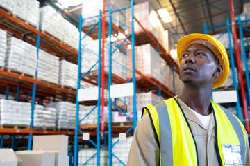 Thoughtful male worker looking away in warehouse