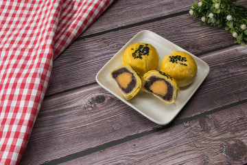 Exquisite and enticing Asian yellow pastry cuisine placed on a retro wood dining table top view