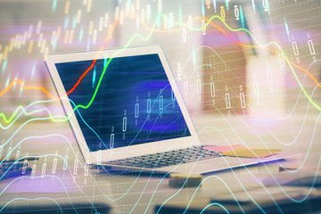 Stock market graph on background with desk and personal computer. Multi exposure. Concept of financial analysis.