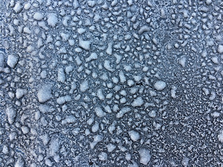 Background of snowflakes on a black metal.