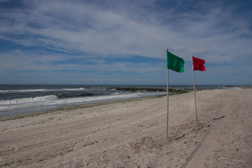 Warning sign of a red flag at a beautiful beach with a blue sky , Long Beach, New York, USA