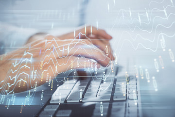 Multi exposure of graph with man typing on computer in office on background. Concept of hard work. Closeup.