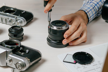 Repair of photographic equipment. Engineer - technician engineer disassembling, align and adjusts photo camera lens, optic part.