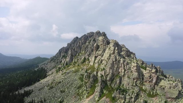 aerial view of ural nature. drone flying over steep stony slope with coniferous, deciduous mixed forest at foot of mountain. natiounal park, ecological protected area in Russia, Otkliknoy greben mount