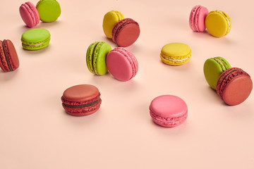 Colored macaron or macaroon, sweet meringue-based confection on pink background. Close-up, copy space.