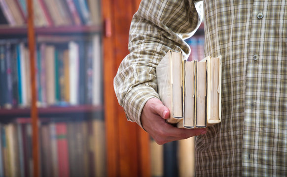 Boy carries books in the library