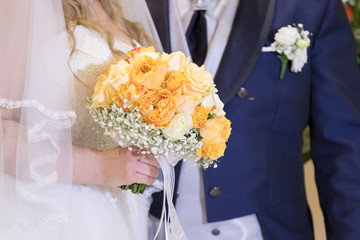 Milan, Italy - July 20, 2019: Bride, with the groom at her side, holds the bouquet of flowers during the wedding ceremony
