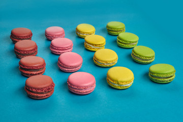 Colored macaron or macaroon, sweet meringue-based confection on blue background. Close-up, copy space.