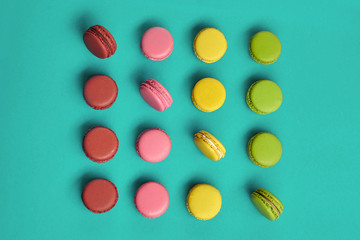 Colored macaron or macaroon, sweet meringue-based confection on blue background. Close-up, copy space.