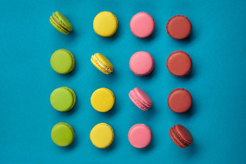 Colored macaron or macaroon, sweet meringue-based confection on blue background. Close-up, copy space.