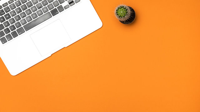 Flat lay latop keyboard with orange background