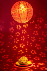 Obraz premium Chinese Mid-Autumn Festival gourmet moon cakes and hollow flower cage lights