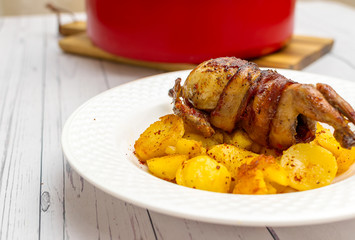 Roasted quail wrapped in bacon and sauteed potatoes