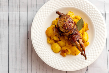 Roasted quail wrapped in bacon and sauteed potatoes