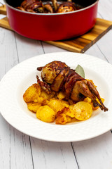 Roasted quail wrapped in bacon and sauteed potatoes