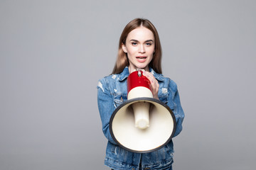Young woman screaming in megaphone with arm isolated gray background