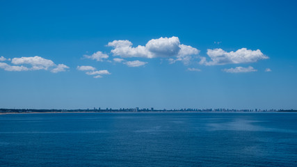 Dekorative Wolkenbildung über einer fernen Skyline in einer intensiv blauen Umgebung