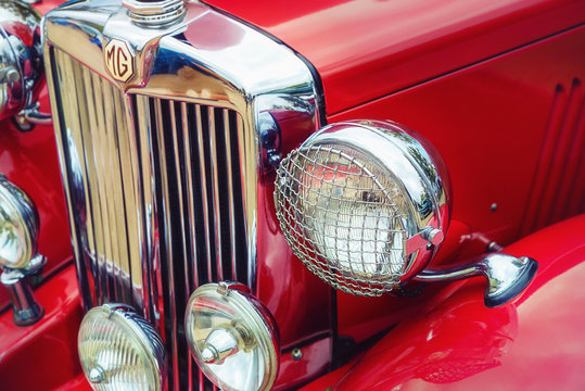 Closeup of headlights and the grille of a red 1951 MG TD classic car on October 21, 2017 in Westlake, Texas.