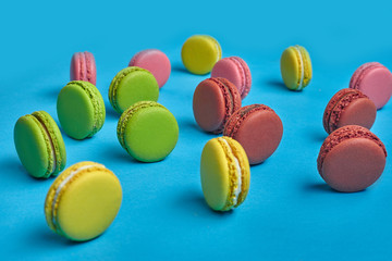 Colored macaron or macaroon, sweet meringue-based confection on blue background. Close-up, copy space.