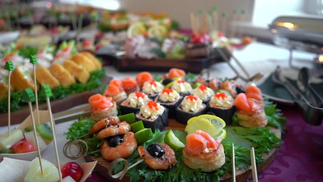 A set of seafood rolls with fish, caviar, shrimps and cream cheese on a buffet table, dolly in