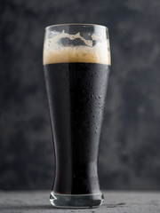 A glass of dark beer on a dark background . Dark strong coffee porter