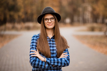 Fashion outdoor portrait of young woman with hat and glasses in fall, retro style color tones. Female fashion.