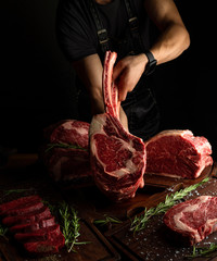 Butcher showing rack of ribs. Low key image, vertical orientation.