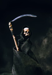 conventional death symbol with a slanting skull in a dark robe with a hood on a dark background