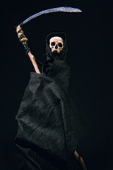 conventional death symbol with a slanting skull in a dark robe with a hood on a dark background