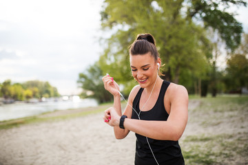 Female fit jogger watching at smart watch