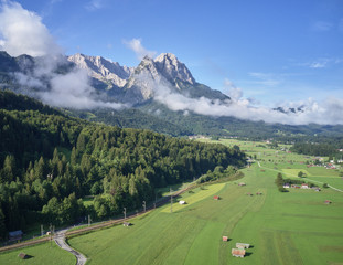 Fototapeta na wymiar Aerial photo, of a meadow and pasture in Bavaria at the edge of the Alps with sheds and barns