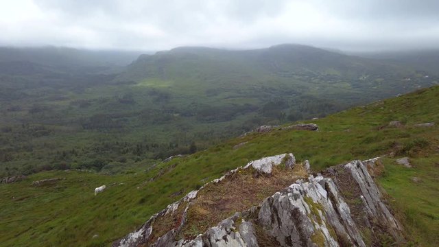 Misty Irish rugged mountain misty valley scene.  Rocks in foreground.