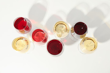 Flat lay composition. Glasses with different wine on white background, top view