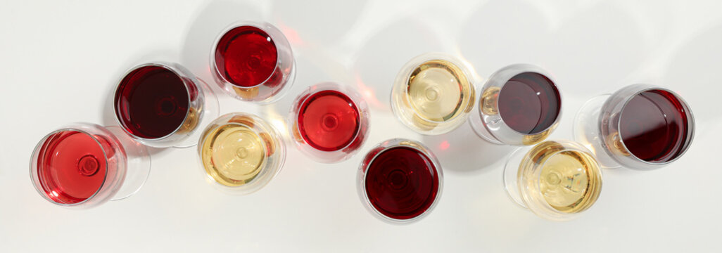 Flat lay composition. Glasses with different wine on white background, top view