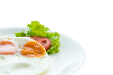 Simple breakfast, two eggs, lettuce and tomato slides on isolated white background.
