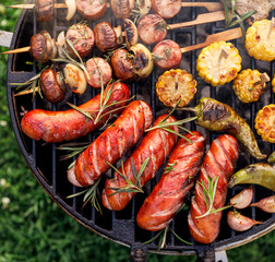 Grilled food, grilled sausages and vegetables on a bbq grill plate, outdoor, top view, close-up. 