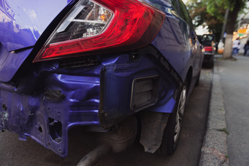 Back of a blue modern car after a crash accident. Vehicle without a bumper. Repairs needed. Closeup.