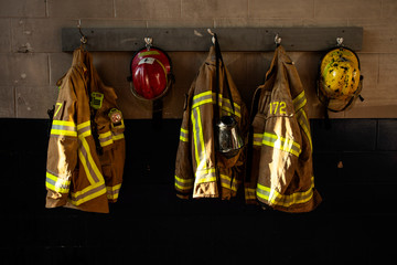 Dirty firefighter protection clothe and helmet hanging on the wall