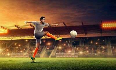 Soccer player in action on a stadium. Kicking the ball. Soccer game. Sports championship. Soccer...