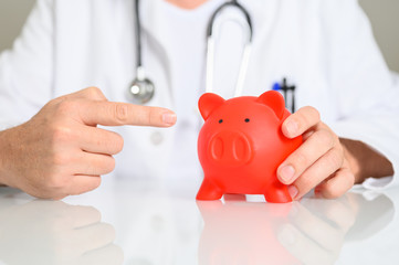 Arzt mit einem Sparschwein