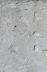 Urban concrete wall background with grooves and bubbles. Cement gray wall. Urban and industrialization art concept. Texture like concrete, stone, cement, plaster.. Poster mockup. Сloseup studio shot.