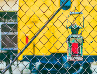 Railway lantern hanging on a fence