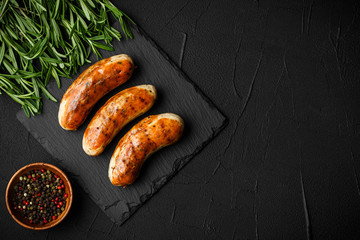grill sausages fried with herbs and spices. on the black board. top view
